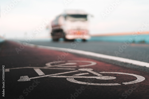 bicycle lane sign with blurred truck in background, safety road and insurance concept