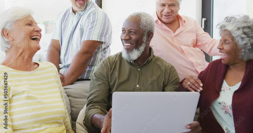 Happy senior diverse people talking and using laptop at retirement home Happy senior diverse people talking and using laptop at retirement home