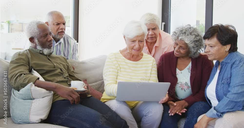 Happy senior diverse people talking and using laptop at retirement home Happy senior diverse people talking and using laptop at retirement home