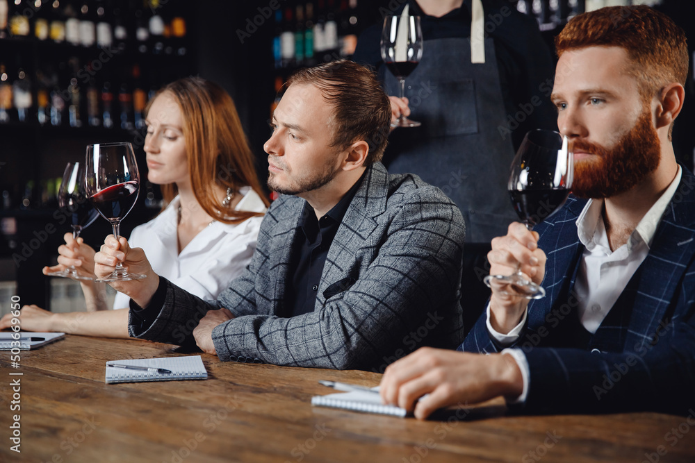 Tasting of red wine from glasses in restaurant, professional meeting of sommelier to choose alcoholic card for menu