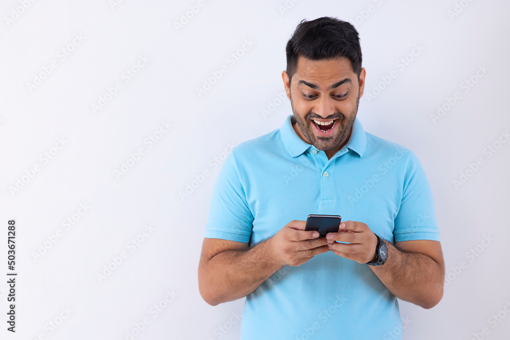 Portrait of a young man using Smartphone against white background Portrait of a young man using Smartphone against white background