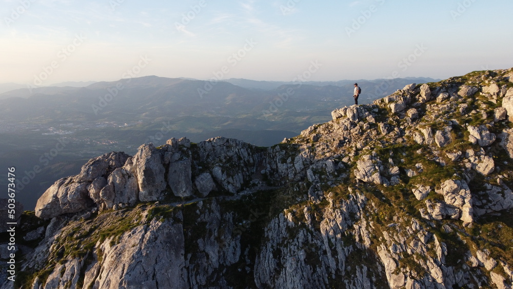 man standing on the top of a mountain at sunset in Urkiola Natural Park in the Basque Country, Spain
