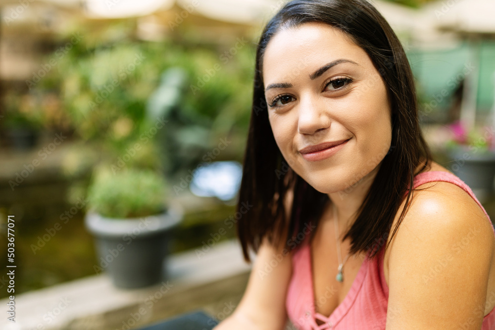 Portrait of young caucasian woman looking at camera relaxing at terrace outdoors in summer Portrait of young caucasian woman looking at camera relaxing at terrace outdoors in summer