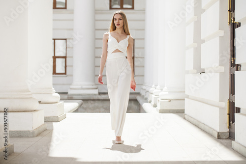 Portrait of a young beautiful blonde model in white trousers © Andrey_Arkusha