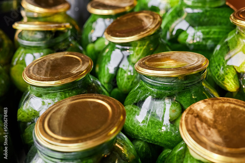 Preservation of fresh home cucumbers in glass jars. Close-up, selective focus