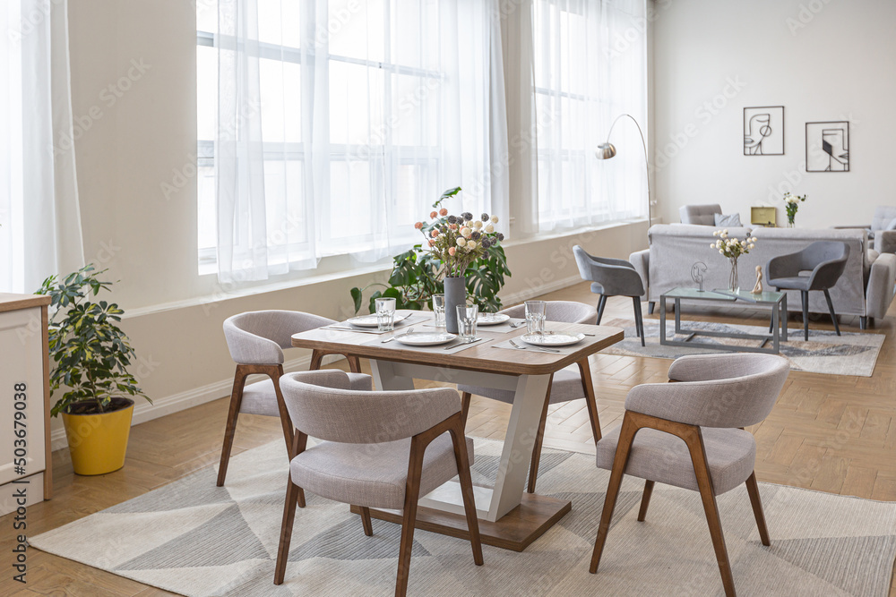 dinnig and kitchen area in minimalist modern interior design huge bright apartment with an open plan in Scandinavian style in white, blue and dark blue colors with columns in the center