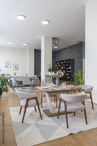 dinnig and kitchen area in minimalist modern interior design huge bright apartment with an open plan in Scandinavian style in white, blue and dark blue colors with columns in the center © 4595886