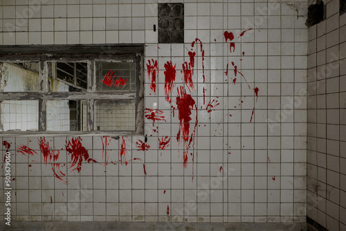 Bloody handprints on a tiled wall and a window