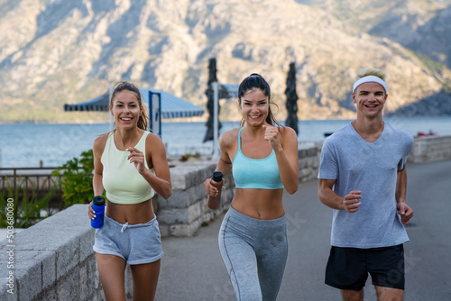Group of friends fitness training together outdoors living active healthy