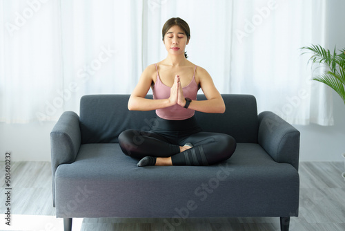 stress relief, muscle relaxation, breathing exercises, exercise, meditation, portrait of Young Asian woman relaxing her body from office work by practicing yoga by watching online tutorials.