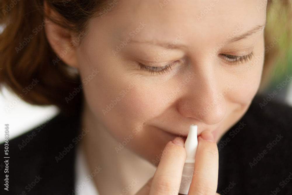 nasal drops, cold treatment, spray for nose in hands of a woman with a runny nose nasal drops, cold treatment, spray for nose in hands of a woman with a runny nose