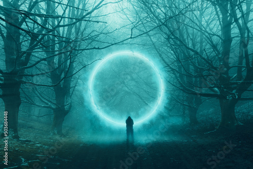 Fototapeta A spooky hooded figure, standing in front of a magical glowing portal floating in a forest