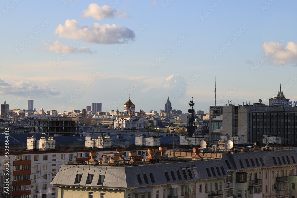 Panorama of Moscow with a view of the Cathedral of Christ the Savior, the monument to Peter I, and other sights of the city on a spring day with expressive clouds in the blue sky.