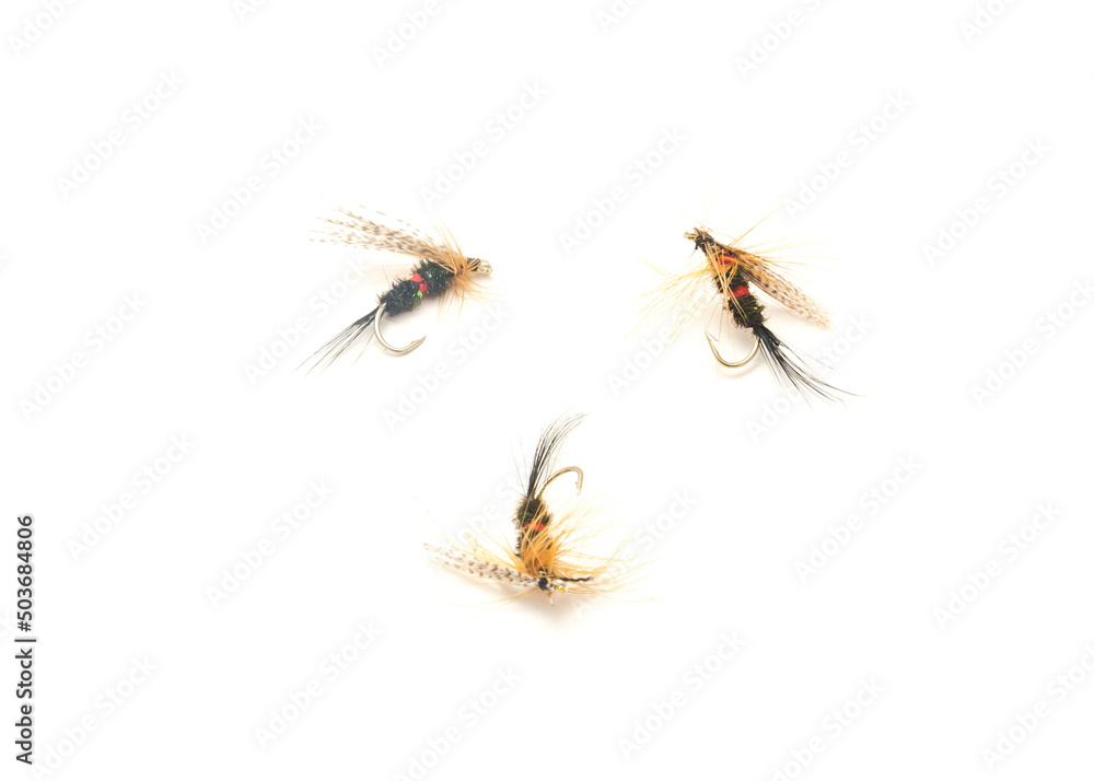 Three fly fishing lures in different files, colors and hook sizes isolated on white background Three fly fishing lures in different files, colors and hook sizes isolated on white background