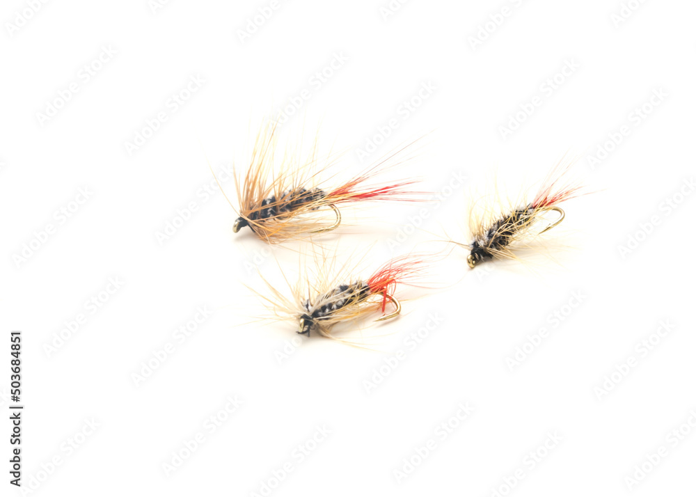 Three fly fishing lures in different files, colors and hook sizes isolated on white background Three fly fishing lures in different files, colors and hook sizes isolated on white background
