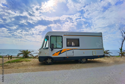 caravan car by the sea in spring season clouds and sun in the sky