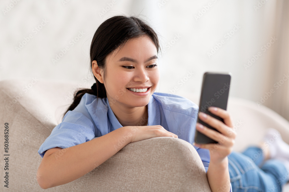 Closeup of cheerful korean woman using smartphone Closeup of cheerful korean woman using smartphone