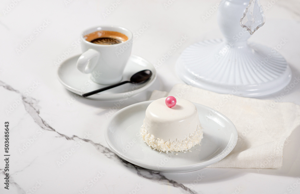 Fresh dessert on a white plate among white dishes with tea and coffee in a cafe Fresh dessert on a white plate among white dishes with tea and coffee in a cafe