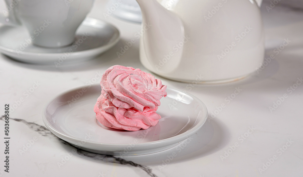 Fresh dessert on a white plate among white dishes with tea and coffee in a cafe Fresh dessert on a white plate among white dishes with tea and coffee in a cafe