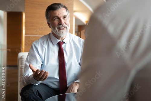 Business meeting. Two business people sitting in front of each other in the office while discussing something.