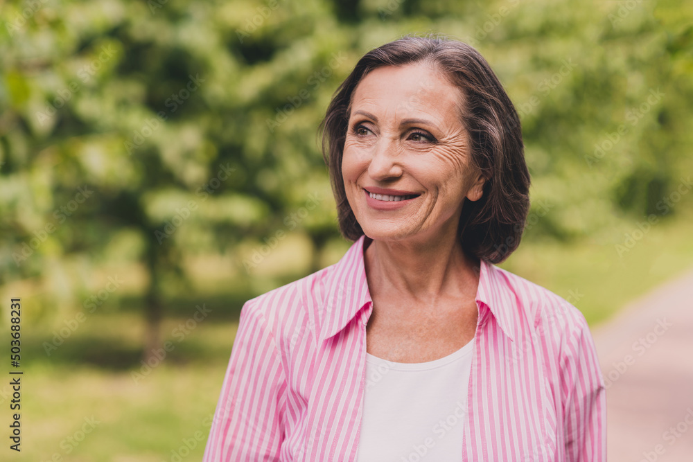 Photo of sweet dreamy retired woman dressed striped shirt walking enjoying good weather outside countryside landscape Photo of sweet dreamy retired woman dressed striped shirt walking enjoying good weather outside countryside landscape