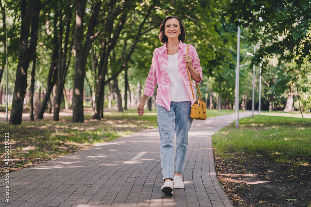 Photo of pretty adorable lady pensioner wear pink shirt walking smiling outdoors countryside garden Photo of pretty adorable lady pensioner wear pink shirt walking smiling outdoors countryside garden