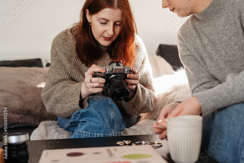 Redhead taking a photo of the jewelry with a digital camera photo