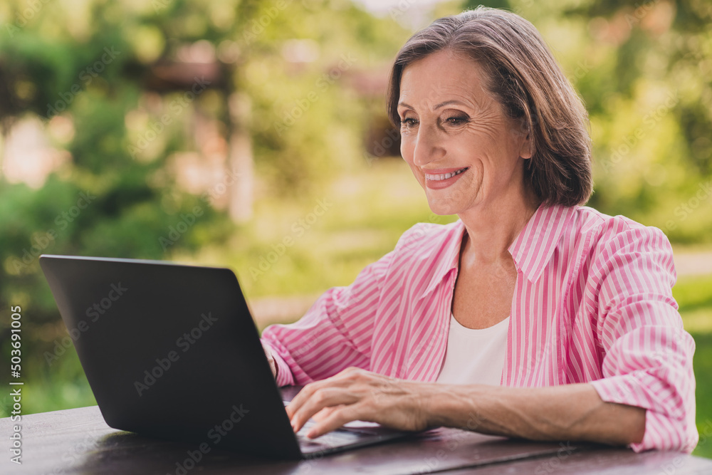 Photo of positive peaceful person use wireless netbook read receive email park outdoors Photo of positive peaceful person use wireless netbook read receive email park outdoors