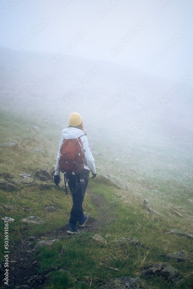 Woman walking in the fog on a hiking path