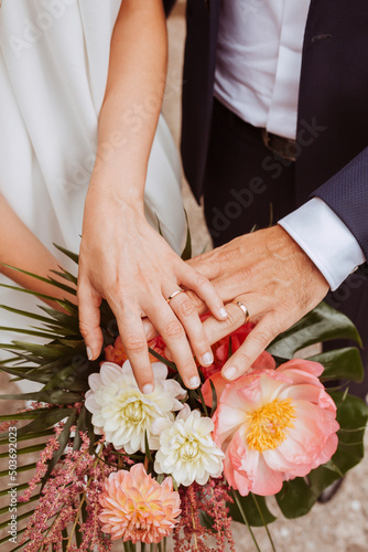 Canvas Print Close up portrait of wedding couple hands with rings and flower bouquet