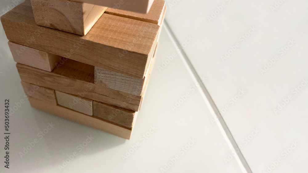 Jenga tower made of wooden blocks on a gray background, a board game for family games, children's development, logical you can build anything from wooden blocks,family fun at the table Jenga tower made of wooden blocks on a gray background, a board game for family games, children's development, logical you can build anything from wooden blocks,family fun at the table