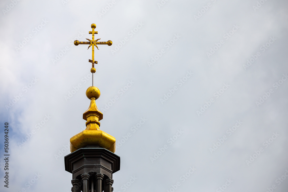 Orthodox cross on top of the church against the cloudy sky. Photo taken in natural light of cloudy day Orthodox cross on top of the church against the cloudy sky. Photo taken in natural light of cloudy day