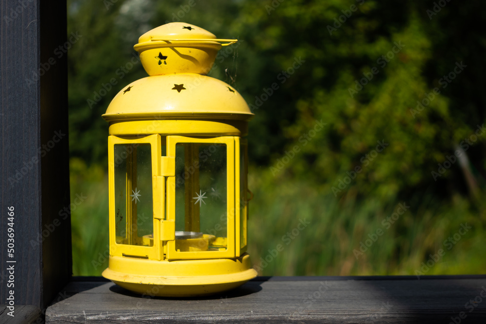 Yellow garden lantern on the balustrade of the garden terrace. Photo taken on a sunny day with good lighting conditions. Yellow garden lantern on the balustrade of the garden terrace. Photo taken on a sunny day with good lighting conditions.