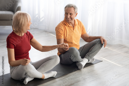 Athletic senior couple meditating together at home