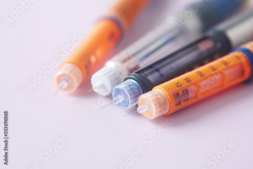Insulin pens on color background, close up 