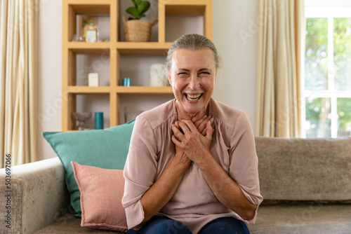 Portrait of happy caucasian senior woman sitting on sofa at home