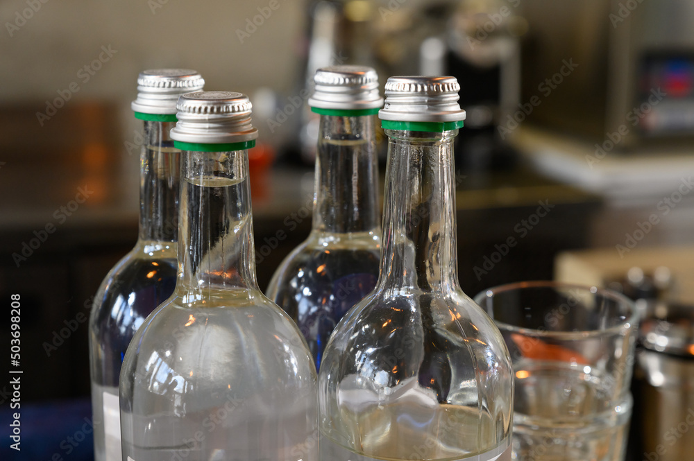 A glass bottle with a metal lid. Bottles with drinks or syrup for cocktails A glass bottle with a metal lid. Bottles with drinks or syrup for cocktails