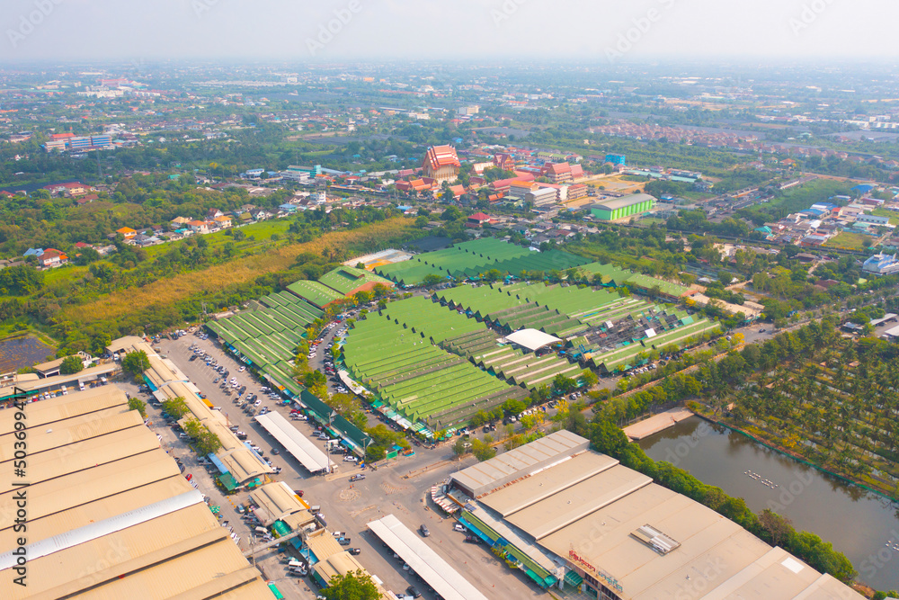 Aerial top view of Sanam Luang street market , green roof tops, horse shoe shape drive thru and parking area. Tents with retail shops.