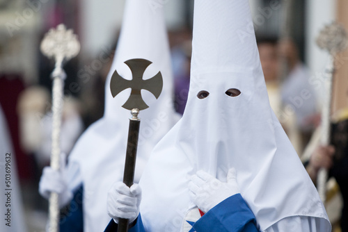 Portrait of a person with a traditional capirote and a cross at the Spanish Holy Week procession photo