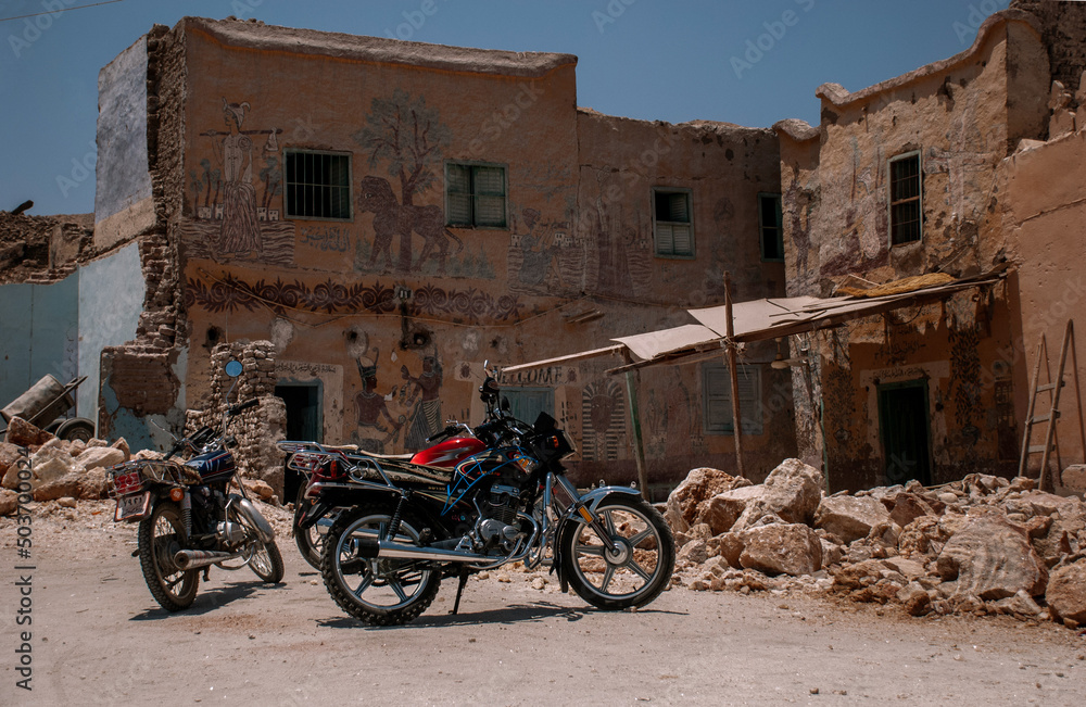 Two motorcycles in an old ruined Egyptian yard