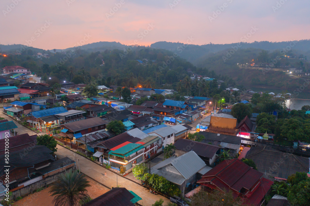Aerial top view of residential local houses in Mon village, nature trees, Kanchanaburi, Thailand in urban city town in Asia, buildings.