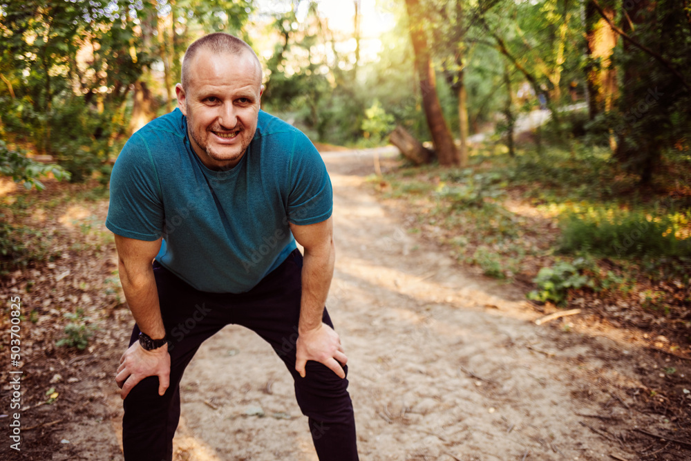 Portrait of athletic mature man after run. Handsome senior man resting after jog at the park on a sunny day. Sweaty multiethnic man listening to music while jogging. Portrait of athletic mature man after run. Handsome senior man resting after jog at the park on a sunny day. Sweaty multiethnic man listening to music while jogging.