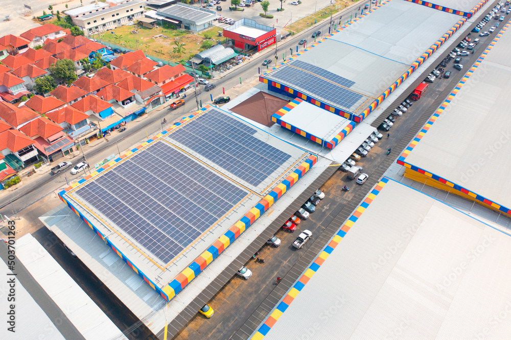 Aerial view of solar panels or solar cells on the roof of shopping mall building rooftop. Power plant, renewable clean energy source. Eco technology for electric power in industry.
