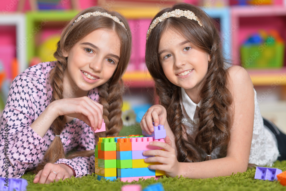 Two girls playing with colorful plastic blocks Two girls playing with colorful plastic blocks