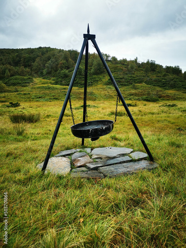 Vertical shot of a tripod campfire in the Reppadalen nature reserve in Arna, Norway photo