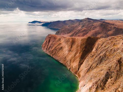 Beautiful coastline of Baikal lake with clear water and mountains. Aerial drone view. Baikal lake, Siberia, Russia. Beautiful spring landscape