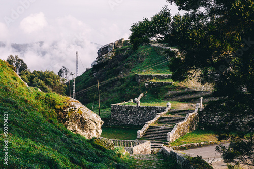 Scenic view of green fields and stonewalls with stairs taking to the top of the mountain photo