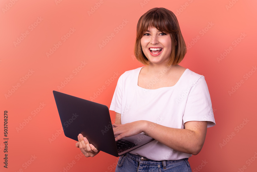 Portrait of attractive amazed cheerful girl agent broker using laptop having fun isolated over pink pastel color background Portrait of attractive amazed cheerful girl agent broker using laptop having fun isolated over pink pastel color background