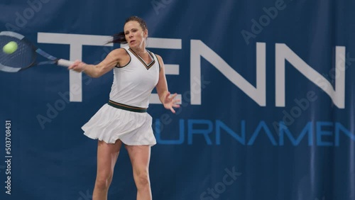 Female Tennis Player Hitting Ball with a Racquet During Championship Match. Professional Woman Athlete Receives and Lands Perfect Backhand Shot. World Sports Tournament. Slow Motion Full Shot Playback photo