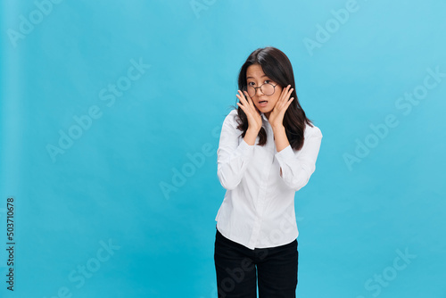 Lovely Asian businesswoman in round glasses classic office dress code recline on hands posing isolated on over blue studio background. Cool business offer. Work Life Balance concept